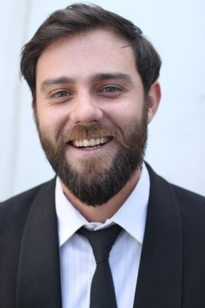 A headshot of Dylan Skews.